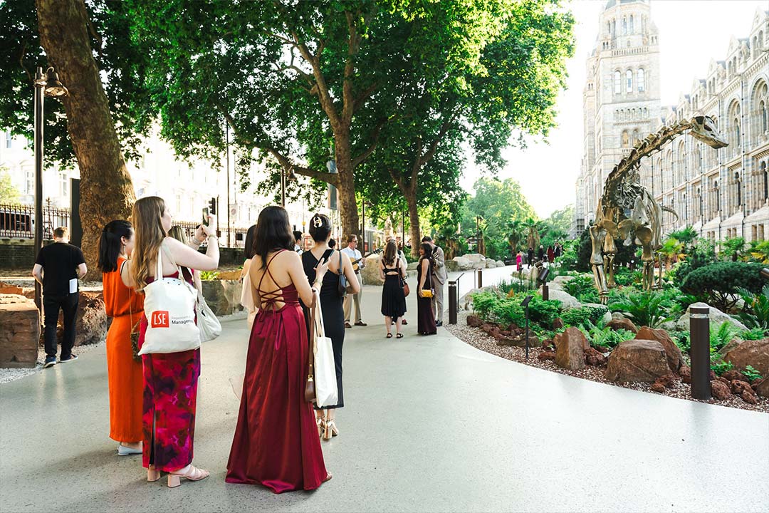Students take in the view of an iconic dinosaur skeleton with the backdrop of the Natural History Museum