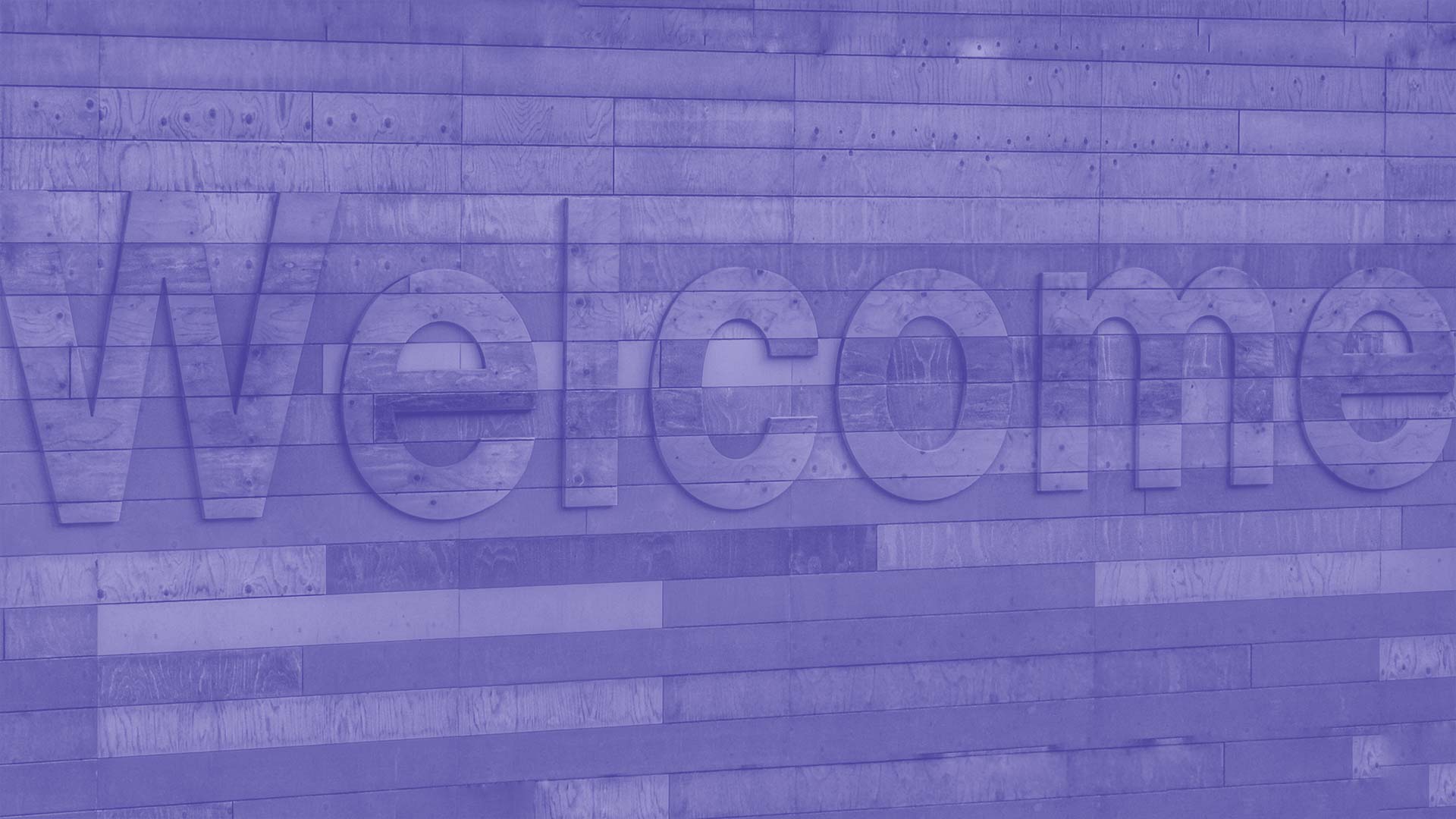 "Welcome" written on a wooden panelled wall