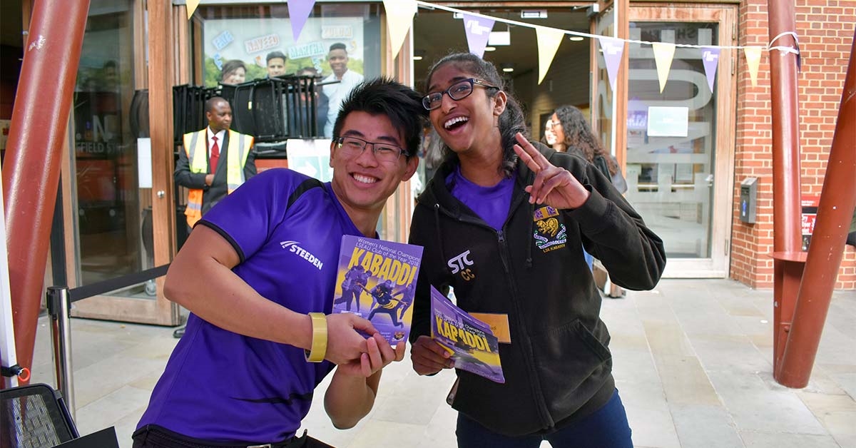 Two students posing for a photo outside the Saw Swee Hock building