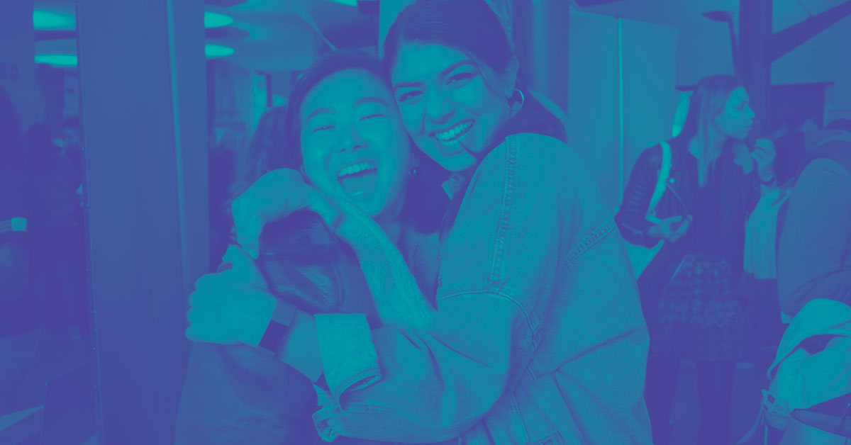 Two students pose for a photograph at an event.