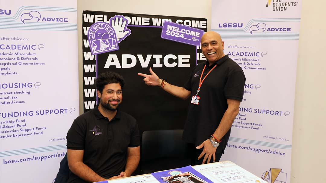 LSESU's Advice Team at Welcome Fair, posing next to a banner and smiling