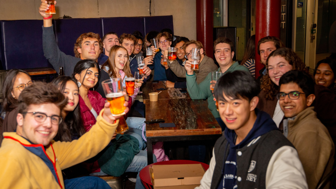 Students enjoying drinks at a table in the Three Tuns