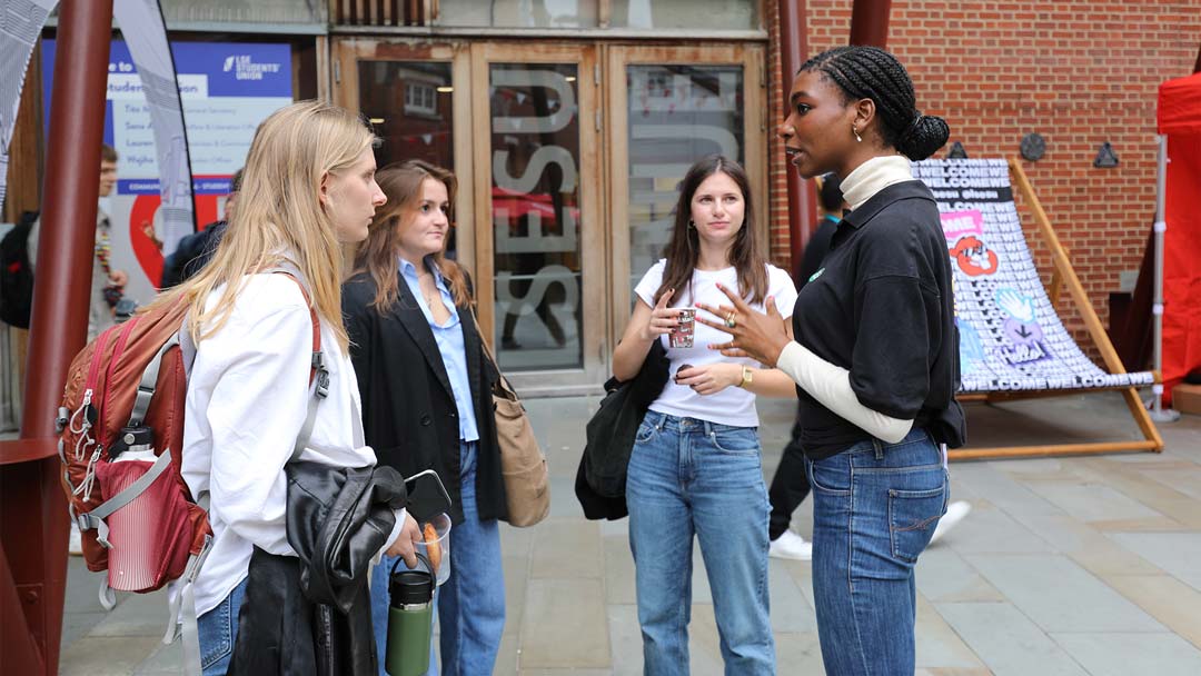 A group of students talking to a staff member outside the LSESU building