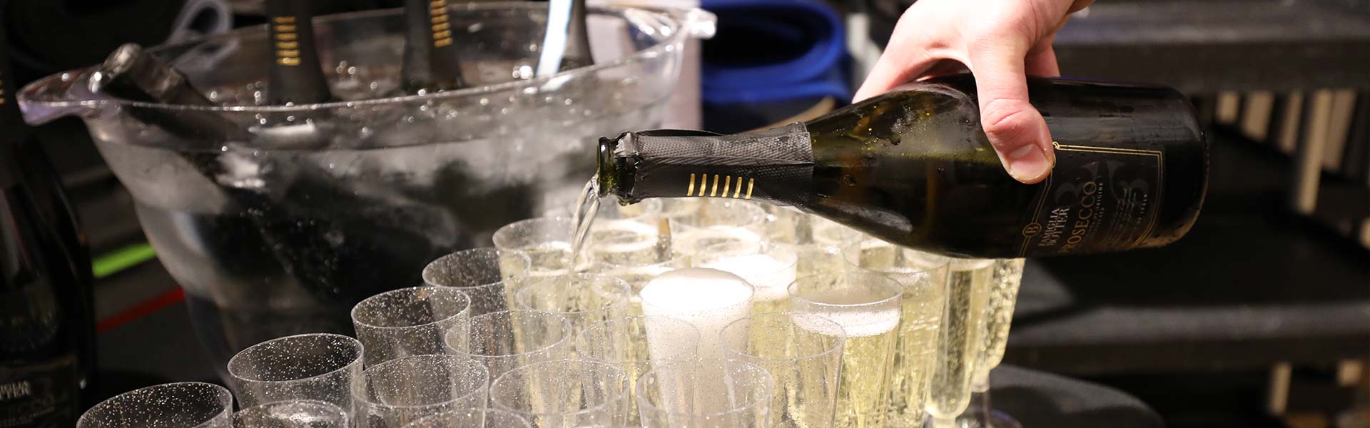 A photograph of someone pouring prosecco