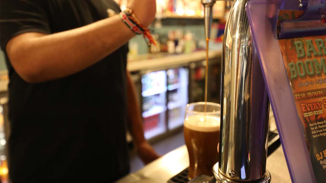 Bar staff pouring a pint at The Three Tuns